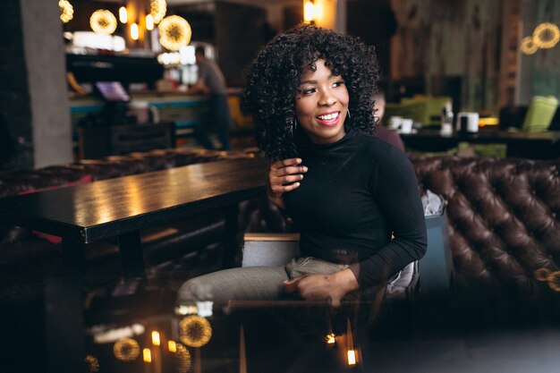 Mujer afroamericana feliz en un café