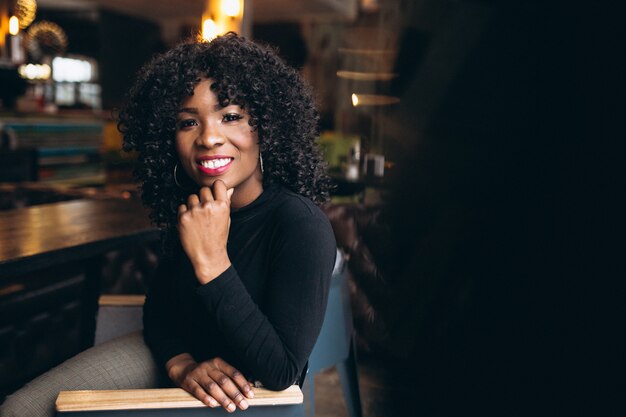 Mujer afroamericana feliz en un café