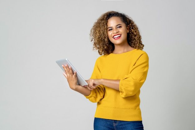 Mujer afroamericana feliz usando su dispositivo electrónico