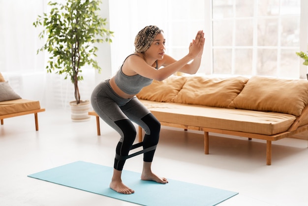 Mujer afroamericana en forma haciendo ejercicios de fitness en casa joven afroamericana delgada