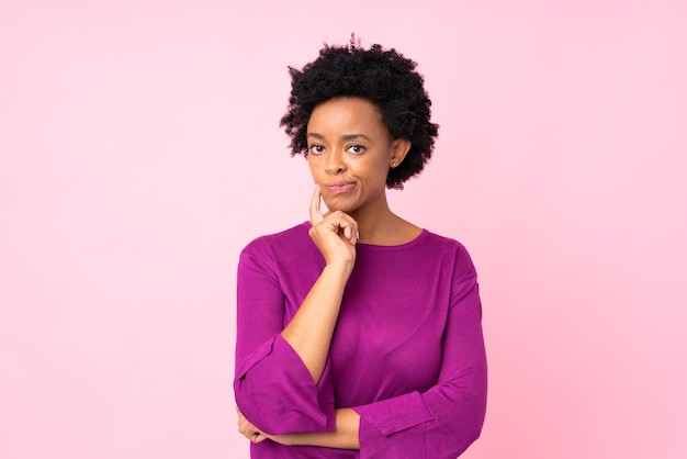 Mujer afroamericana en frente mirando rosa aislado