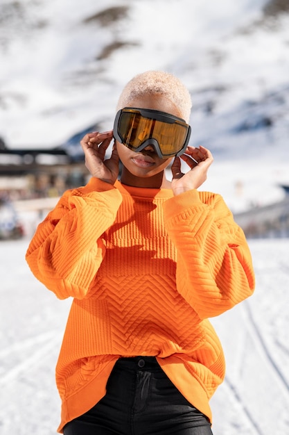 Foto una mujer afroamericana con gafas de nieve en una montaña nevada durante el invierno