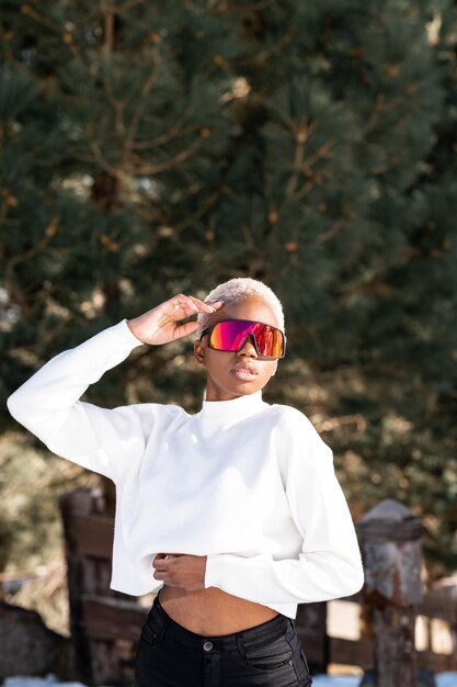 Una mujer afroamericana con gafas de nieve en una montaña nevada durante el invierno