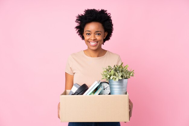 Mujer afroamericana haciendo un movimiento sobre pared rosa