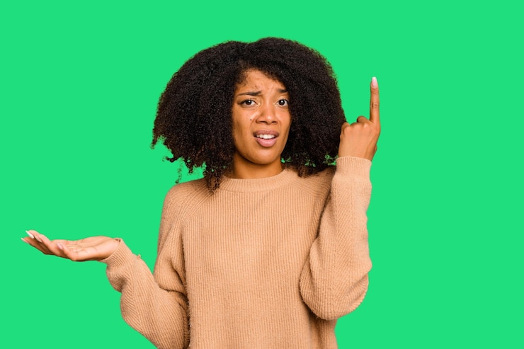 Foto mujer afroamericana joven aislada sosteniendo y mostrando un producto en la mano