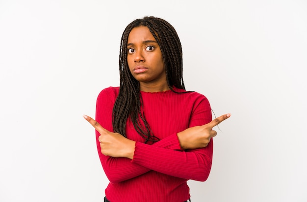 La mujer afroamericana joven aisló puntos de lado, está intentando elegir entre dos opciones.