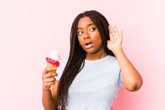 La mujer afroamericana joven que sostenía un helado aisló intentar escuchar un chisme.