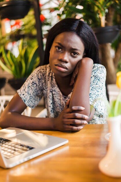 Mujer afroamericana con laptop en un café