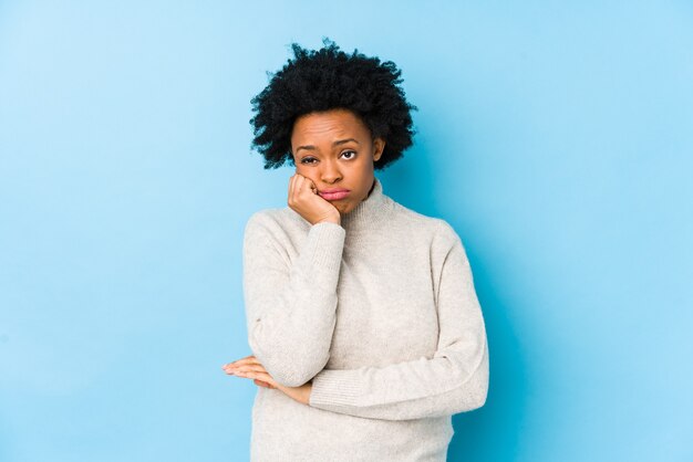 Mujer afroamericana de mediana edad contra una pared azul aislada que está aburrida, fatigada y necesita un día de relax.