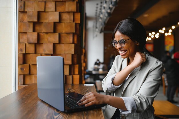 Mujer afroamericana muy feliz leyendo noticias emocionantes en línea