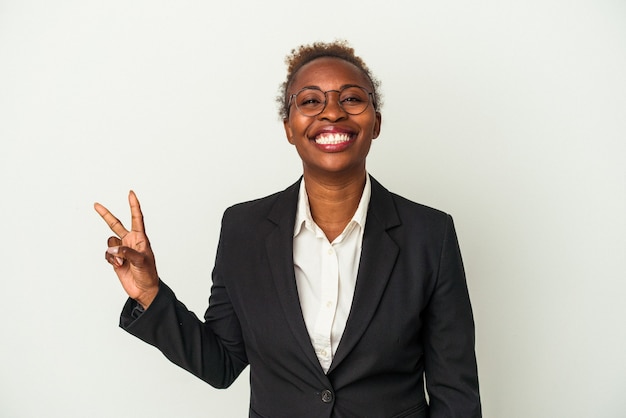 Mujer afroamericana de negocios joven aislada sobre fondo blanco que muestra el signo de la victoria y una amplia sonrisa.