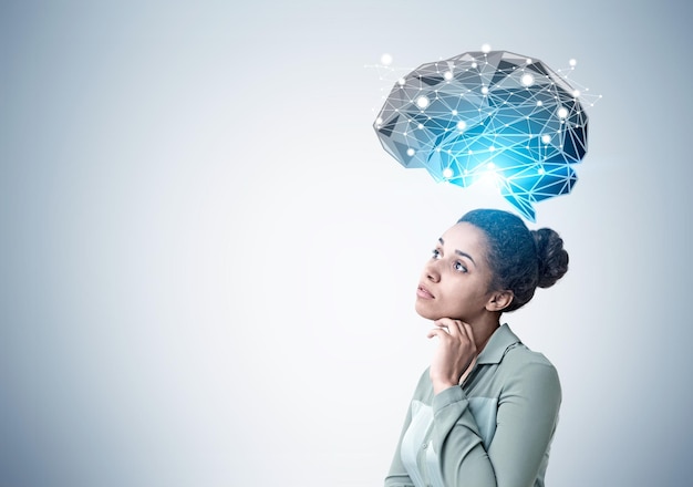 Mujer afroamericana pensativa y holograma del cerebro
