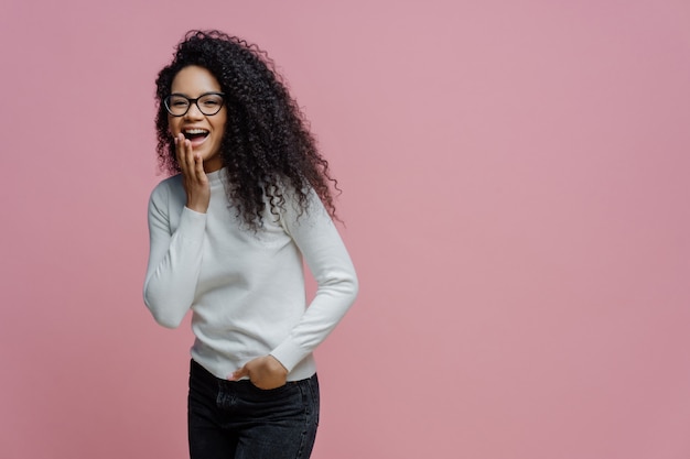 Mujer afroamericana positiva se ríe de algo gracioso