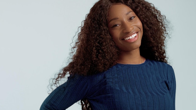 Mujer afroamericana de raza mixta negra de belleza con cabello largo y rizado y sonrisa perfecta