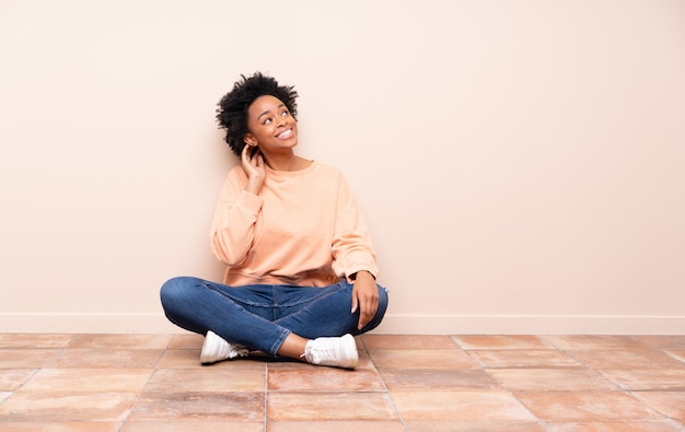 Foto mujer afroamericana sentada en el piso