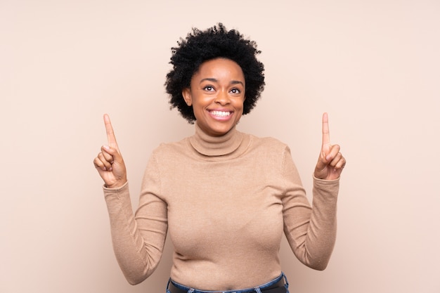 Mujer afroamericana sobre pared beige