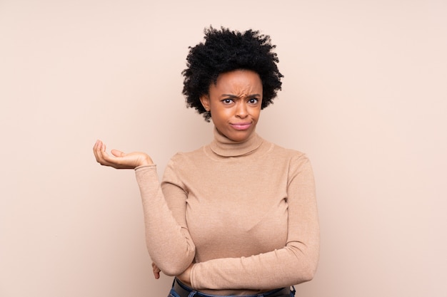 Mujer afroamericana sobre pared beige