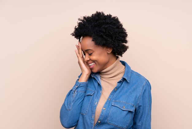 Mujer afroamericana sobre pared beige