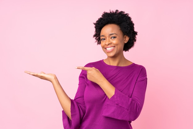 Mujer afroamericana sobre pared rosa