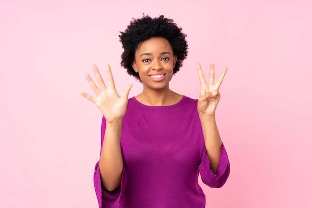 Mujer afroamericana sobre pared rosa