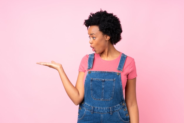 Mujer afroamericana sobre pared rosa