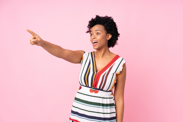 Mujer afroamericana sobre pared rosa