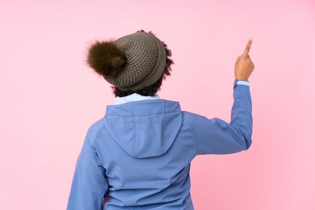 Foto mujer afroamericana con sombrero de invierno sobre pared rosa aislado