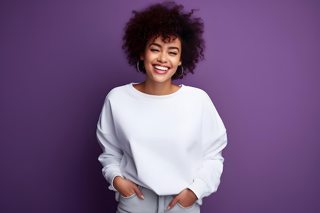 Una mujer afroamericana sonriente con un suéter blanco en la parte delantera en un fondo de estudio púrpura