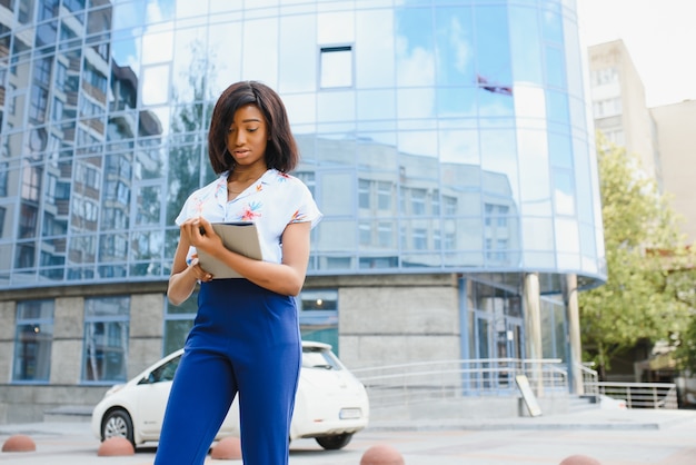 Mujer afroamericana con tablet PC en el fondo urbano