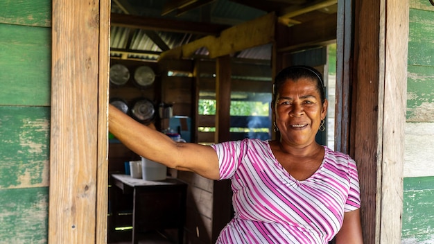 Foto mujer afrodescendiente desde la puerta de su casa de madera en el caribe de nicaragua