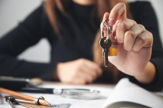 Mujer agente de bienes raíces con llave de la casa