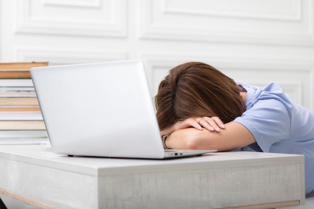 Una mujer agotada durmiendo en su escritorio.