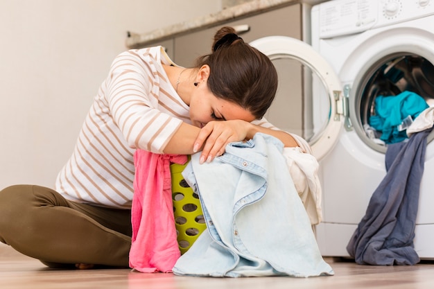 Mujer agotada lavando ropa