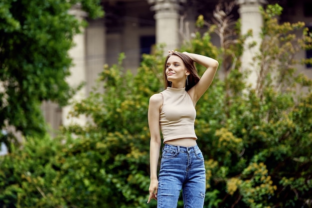 Mujer agraciada en jeans se encuentra en el parque durante el día