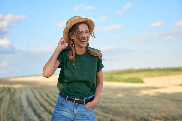 Mujer agricultor sombrero de paja de pie tierras de cultivo