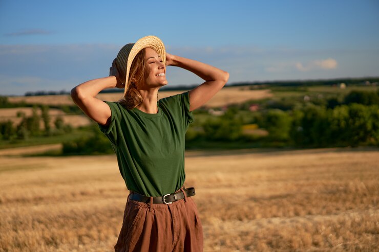Mujer agricultor sombrero de paja de pie tierras de cultivo