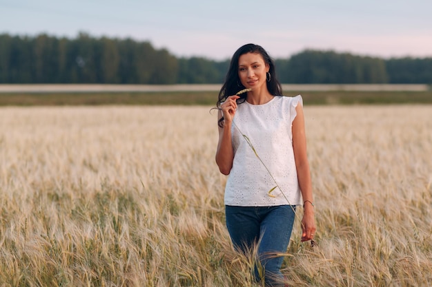 Mujer agricultora camina en el campo agrícola