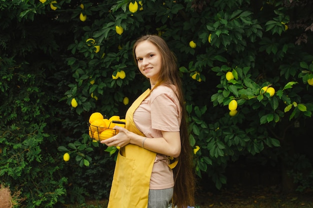 Mujer agricultora con una canasta de limones en sus manos