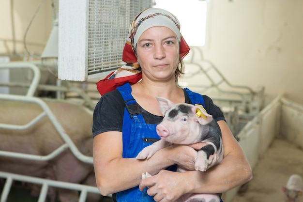 Mujer agricultora en mano con un lechón