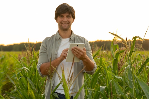 Mujer agricultora monitoreando un cultivo de maíz con una tableta digital