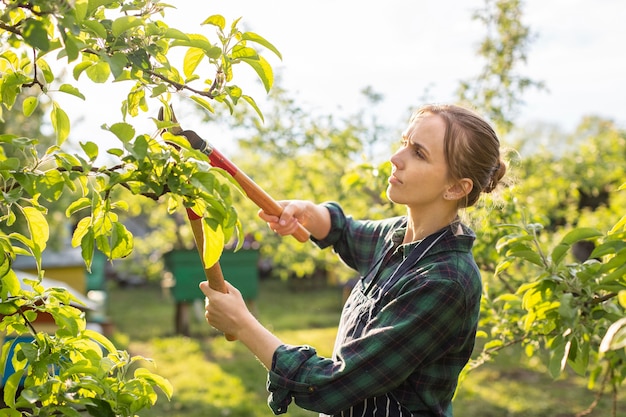 Mujer agricultora podando un árbol