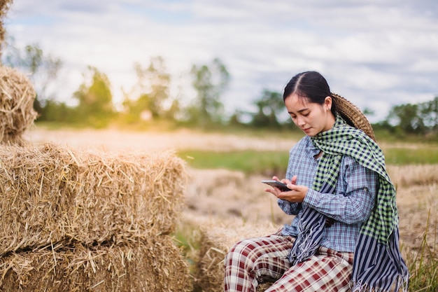 mujer agricultora que usa tecnología móvil en el campo de arroz