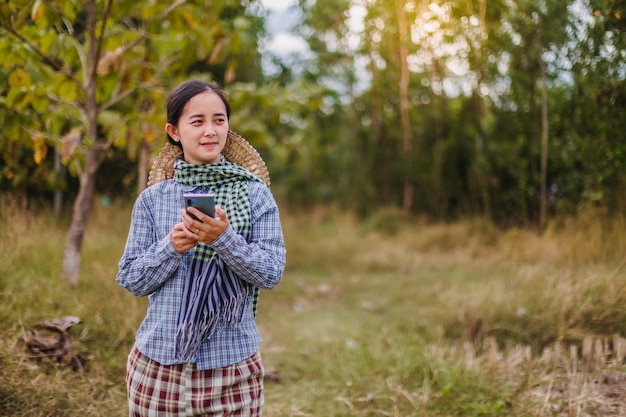 mujer agricultora que usa tecnología móvil en el campo de arroz