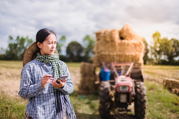 mujer agricultora que usa tecnología móvil en el campo de arroz