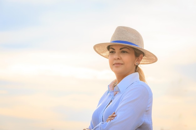 Mujer de agronegocios con sombrero y jeans al final de un día de trabajoxA