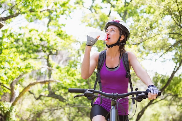 Mujer, agua potable, mientras, bicicleta