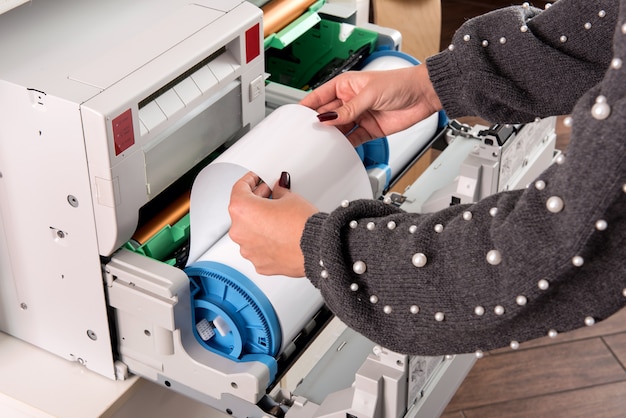 Mujer ajustando un rollo de papel fotográfico nuevo