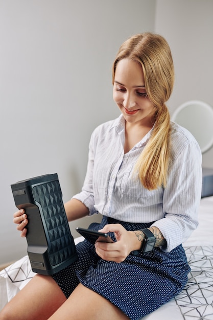 Mujer ajustando el volumen del altavoz