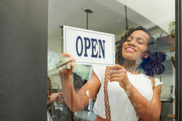 Mujer alegre abriendo tienda