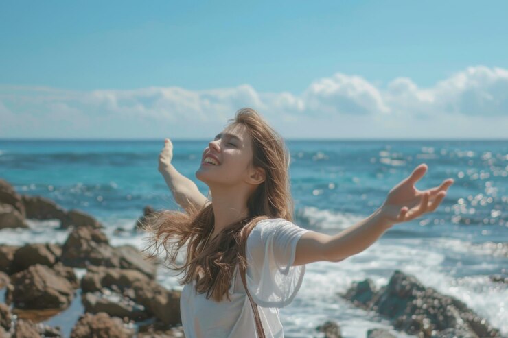 Mujer alegre con los brazos extendidos por el mar